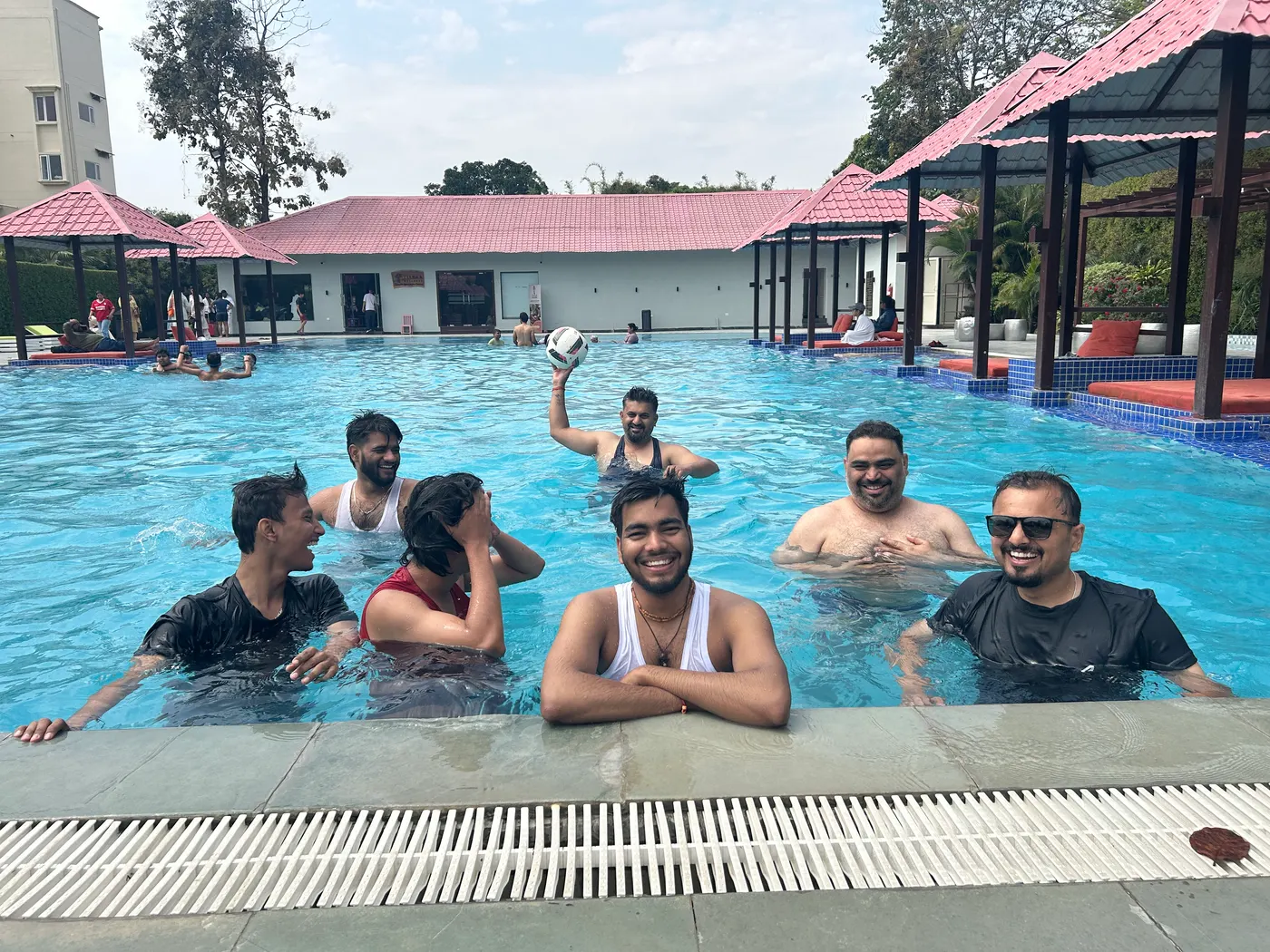 Teammates playing ball in the pool at the company offsite